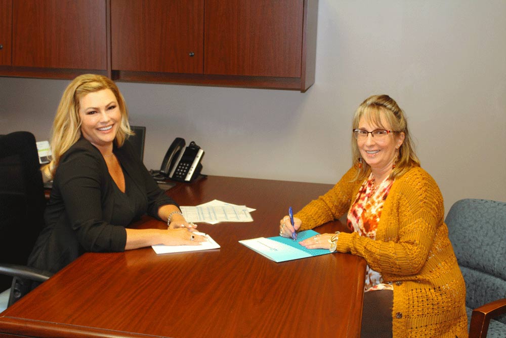 Brentwood Bank employees Tricia Nee and Lisa Schaeffer sitting at a desk.