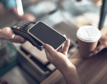Person paying for coffee using mobile wallet.